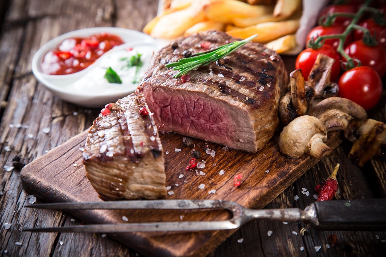 Delicious-beef-steak-on-wooden-table-close-up